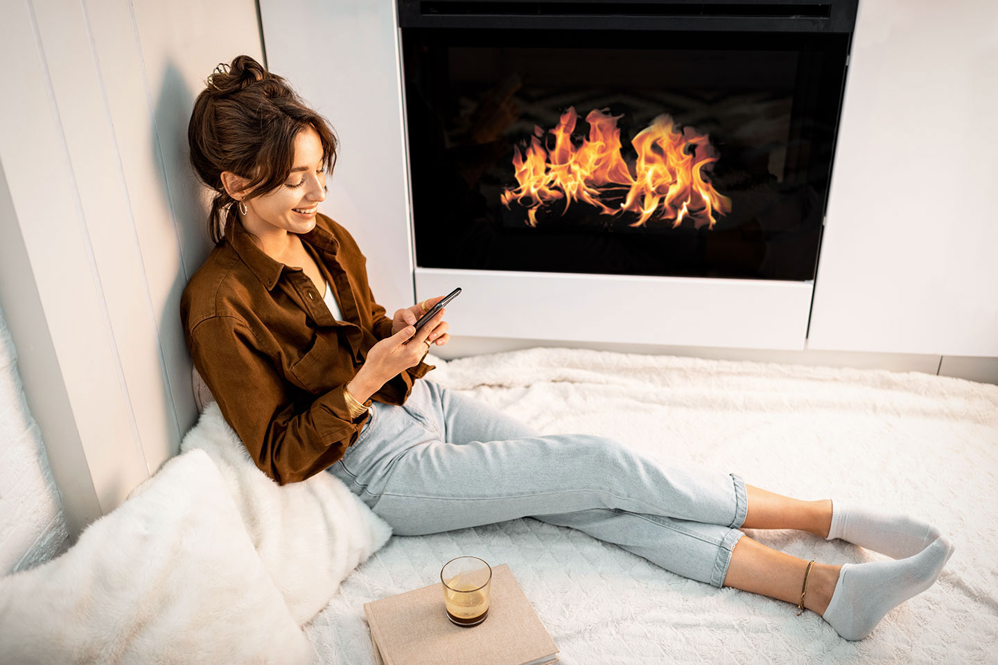 model on phone, next to fireplace
